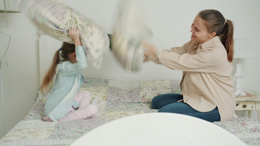 Mae E Filha Tendo Uma Briga De Travesseiros Na Cama dIK1Gh91rzc