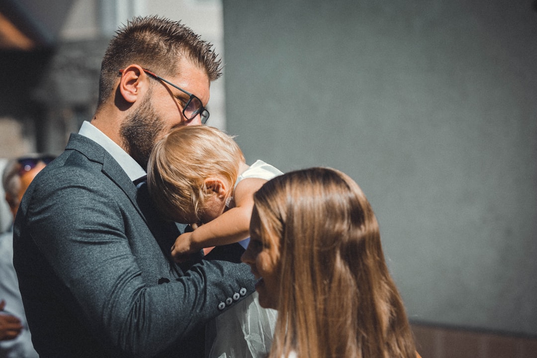 Um Homem Em Um Terno Segurando Uma Crianca Pequena Rds BSbSXbo