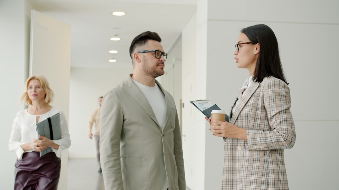 Dois Colegas Conversando Em Um Corredor De Escritorio Moderno igg17b7bRK0